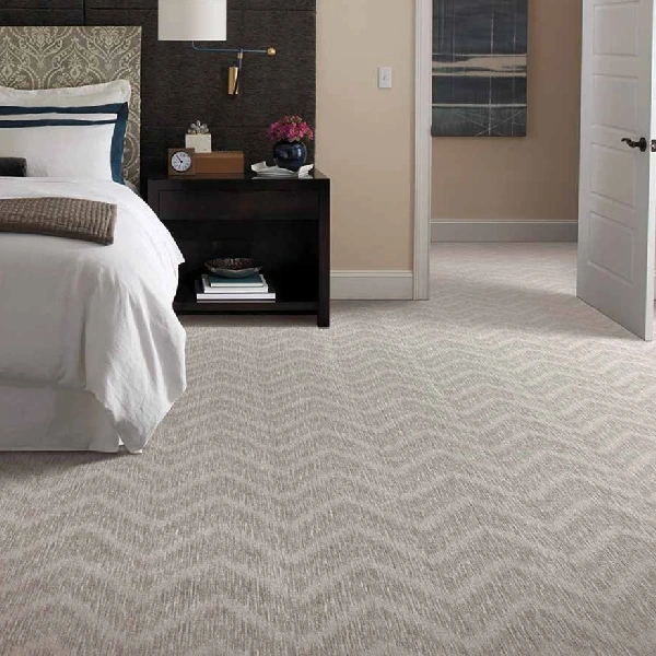 bedroom with a neutral-toned carpet featuring a subtle zigzag pattern