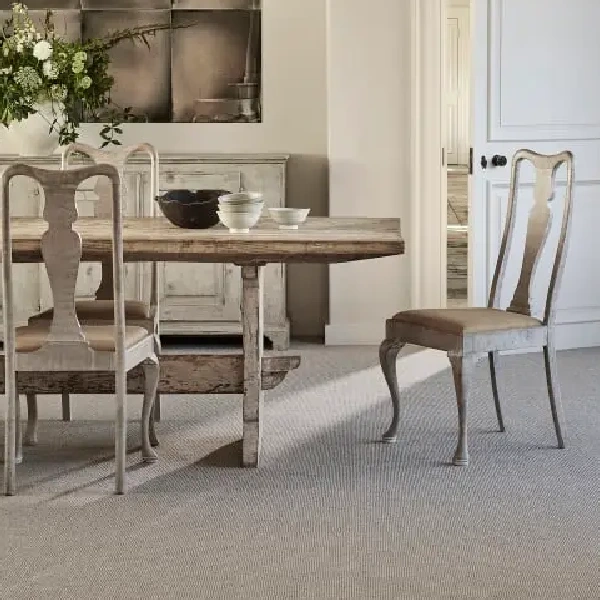 Light gray wall-to-wall textured carpet under a rustic dining table